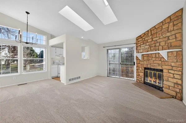 a view of an empty room with fireplace and a window