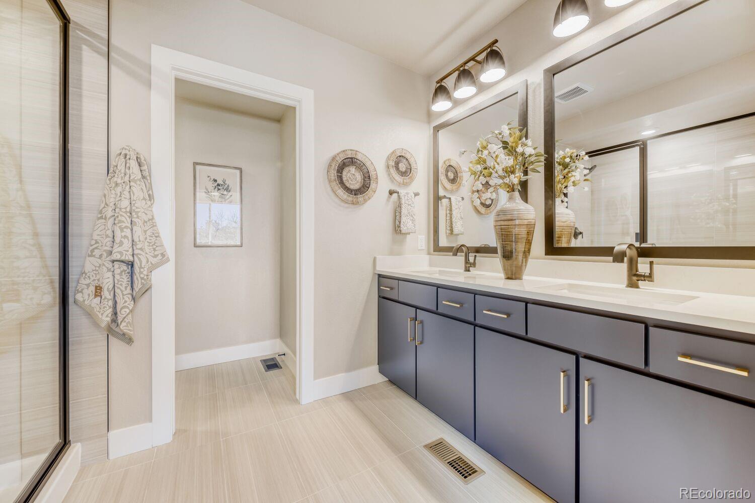 9195 Pierce Street, Unit 2 Westminster, CO 80021 - Photo 22 of 28 a bathroom with a double vanity sink mirror and shower