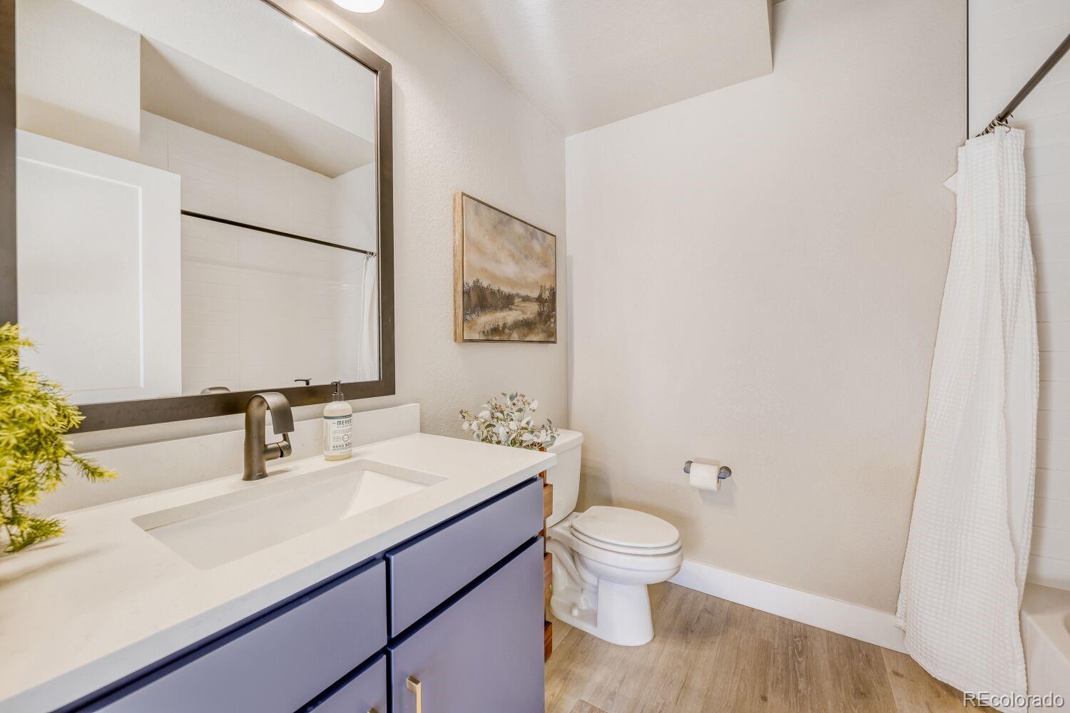 9195 Pierce Street, Unit 2 Westminster, CO 80021 - Photo 24 of 28 a bathroom with a sink a toilet and a large mirror
