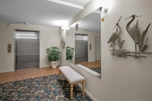 a view of a hallway with furniture and a potted plant