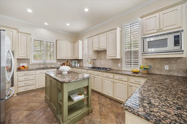 a kitchen with stainless steel appliances granite countertop a stove a sink and a refrigerator