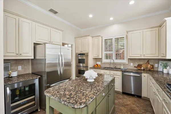 a kitchen with a stove a sink a refrigerator and cabinets