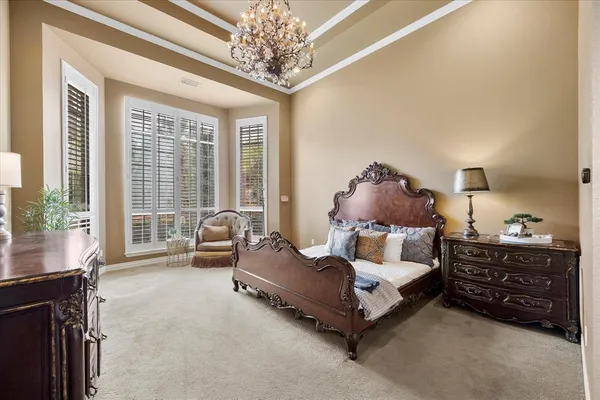 a spacious bedroom with a bed and a chandelier