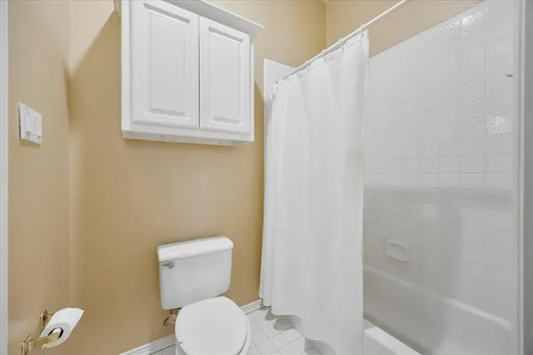 a white toilet sitting next to a bath tub