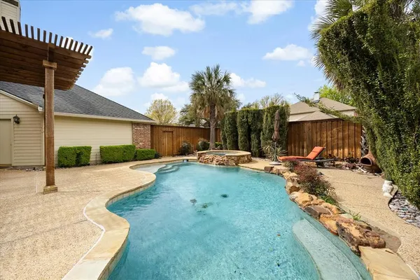 a view of swimming pool with lawn chairs and plants