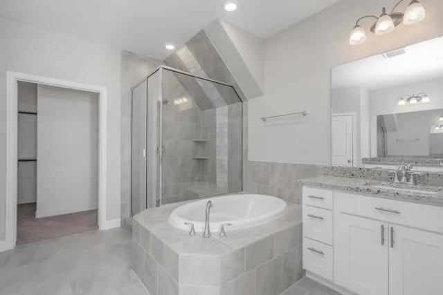 a bathroom with a tub a sink and mirror