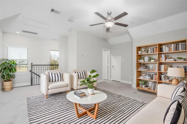 a living room with furniture and a book shelf