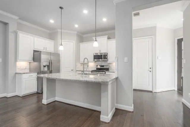 a kitchen with kitchen island a sink stainless steel appliances and cabinets