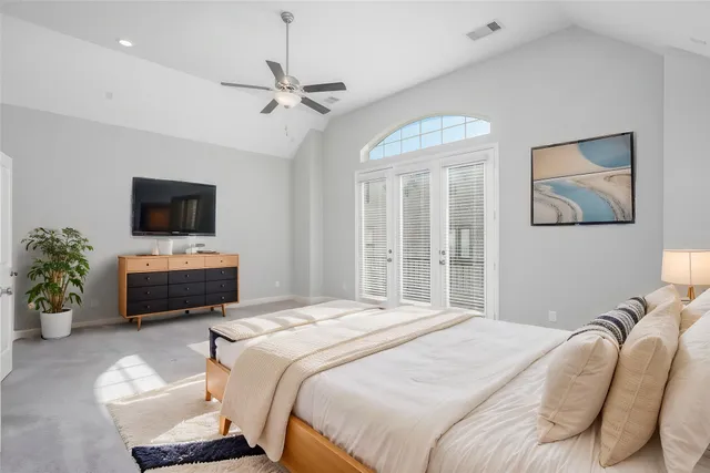 a bedroom with a bed a couch and a potted plant
