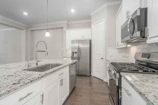 a kitchen with stainless steel appliances granite countertop a sink stove and refrigerator