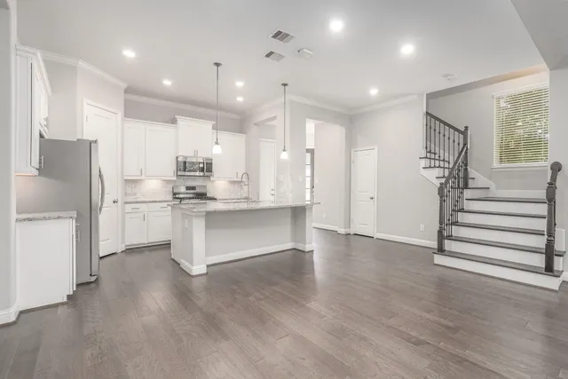 a large kitchen with white cabinets and stainless steel appliances