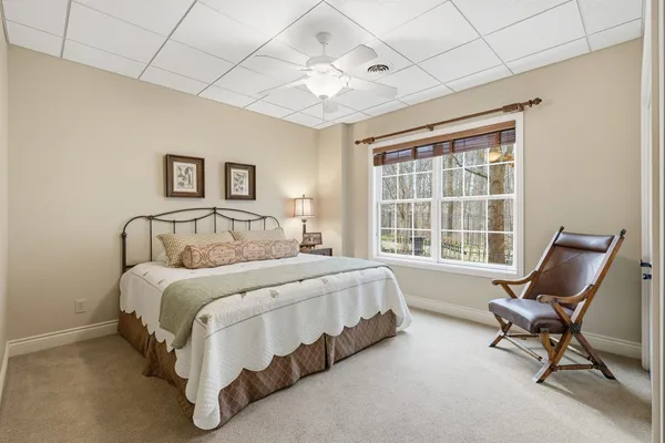 a spacious bedroom with a bed chair and a window