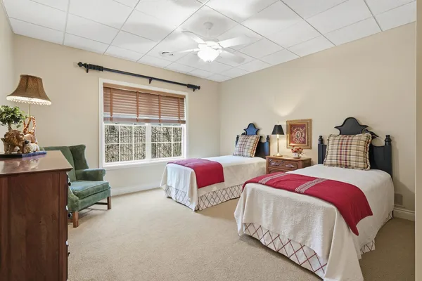 a spacious bedroom with two beds and a chandelier