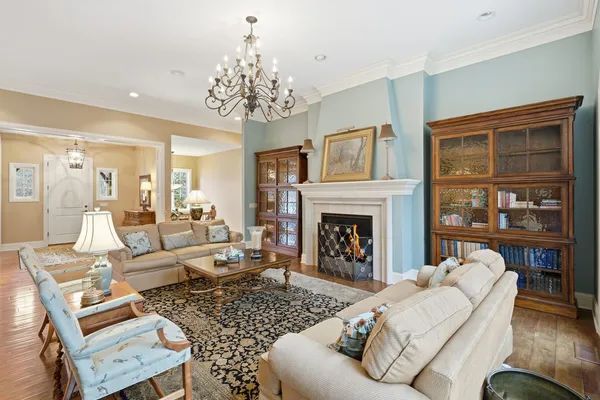 a living room with furniture a fireplace and a chandelier