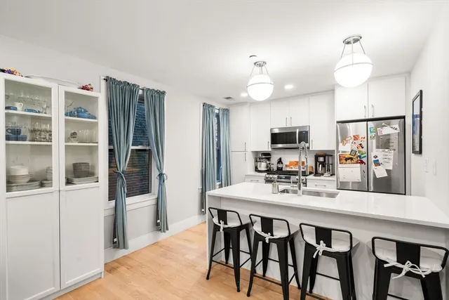 a kitchen with a dining table chairs cabinets and stainless steel appliances