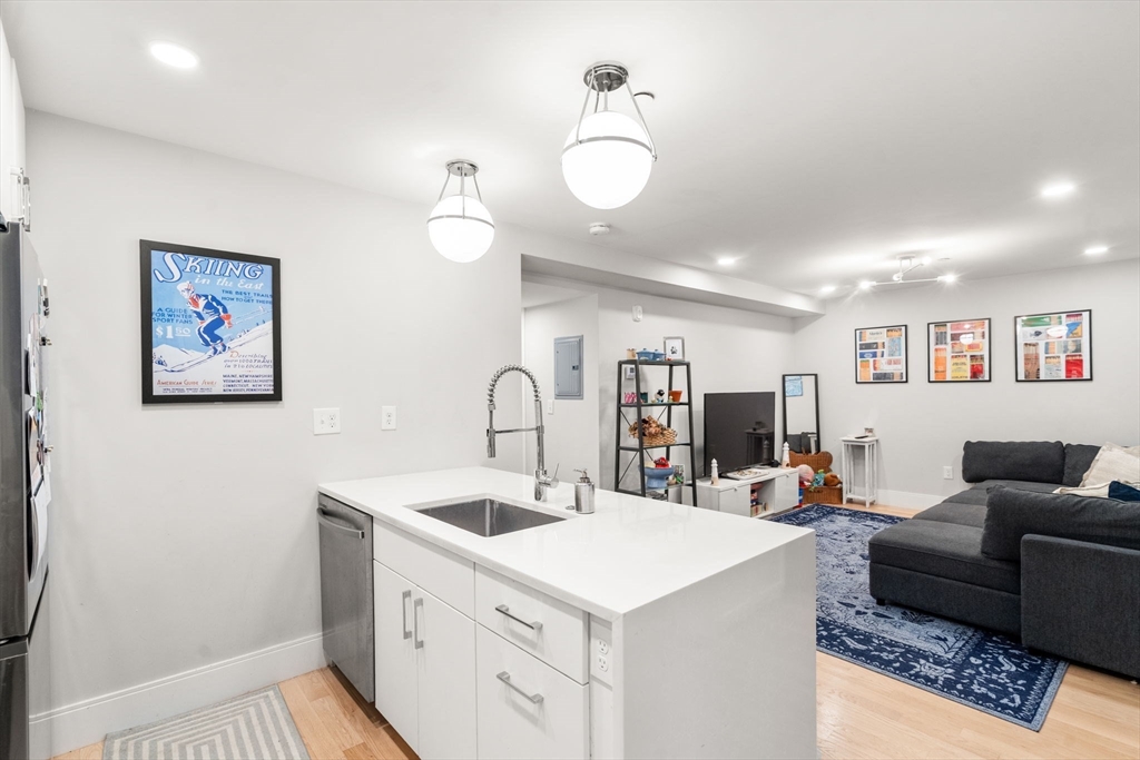 10 Lamson Court, Unit 2 Boston, MA 02128 - Photo 3 of 10 a view of center island with kitchen island a sink wooden floor and living room view