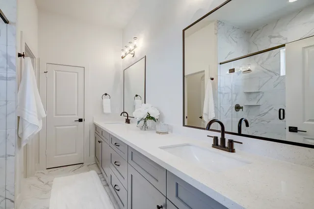 a bathroom with a double vanity sink a mirror and shower