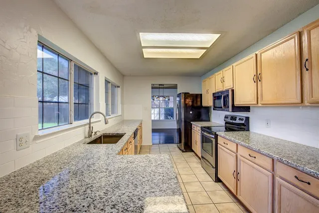 a kitchen with stainless steel appliances granite countertop a sink stove and cabinets