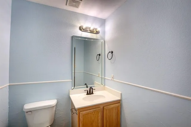 a bathroom with a sink a toilet and mirror
