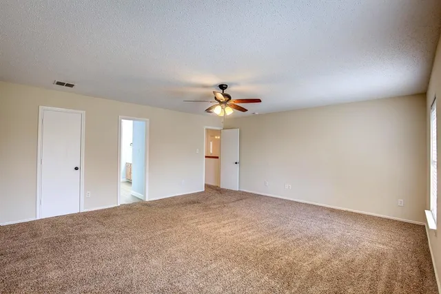 a view of a big room with chandelier fan and windows
