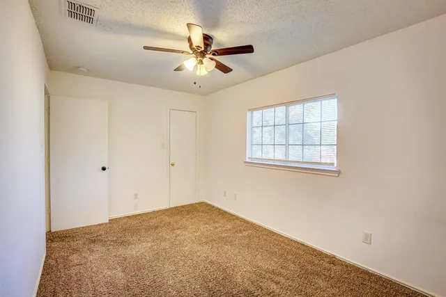 a view of a livingroom with a ceiling fan and window