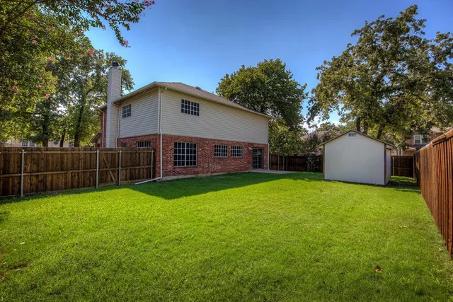 a view of a house with backyard and tree