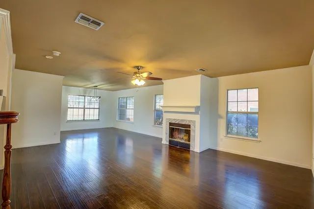 a view of empty room with wooden floor and fireplace