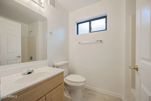 a bathroom with a toilet a sink and mirror