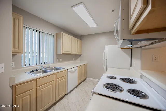 a kitchen with sink a stove and wooden floor