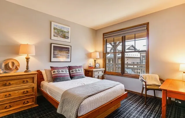 a bedroom with a bed a lamp and a window