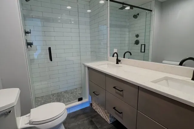 a bathroom with a sink a toilet and shower
