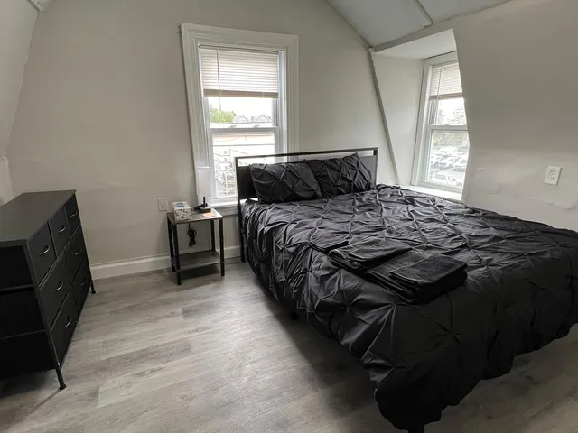 a bed sitting in a bedroom next to a window