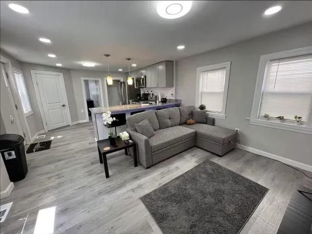 a living room with furniture and a wooden floor
