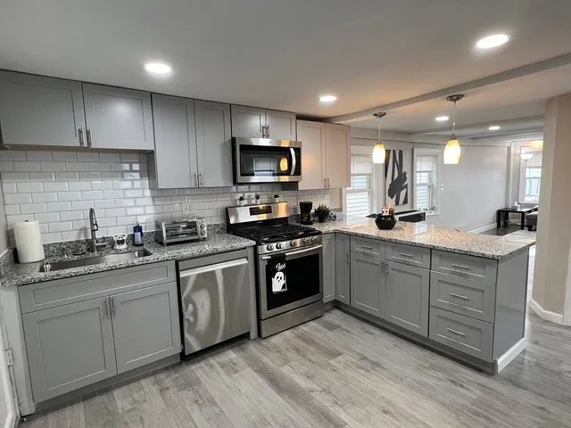 a kitchen with sink a microwave and cabinets