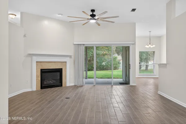 a view of an empty room with a fireplace and a window