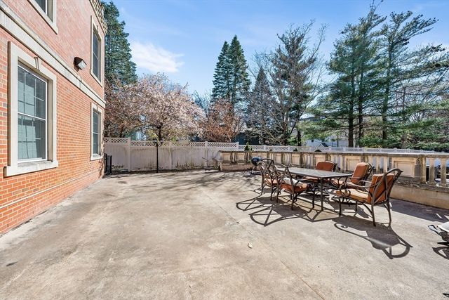 a view of a patio with table and chairs with wooden fence and plants