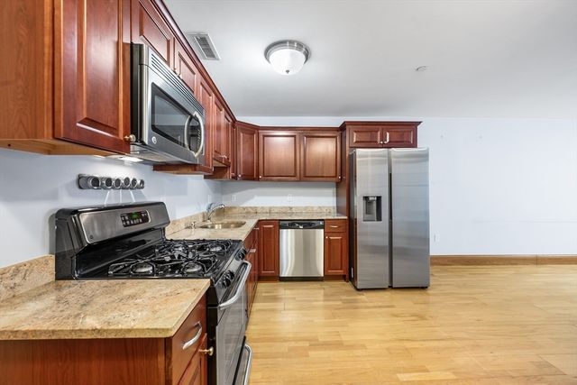a kitchen with stainless steel appliances granite countertop a stove refrigerator and microwave