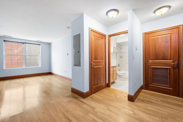 an empty room with windows and cabinet