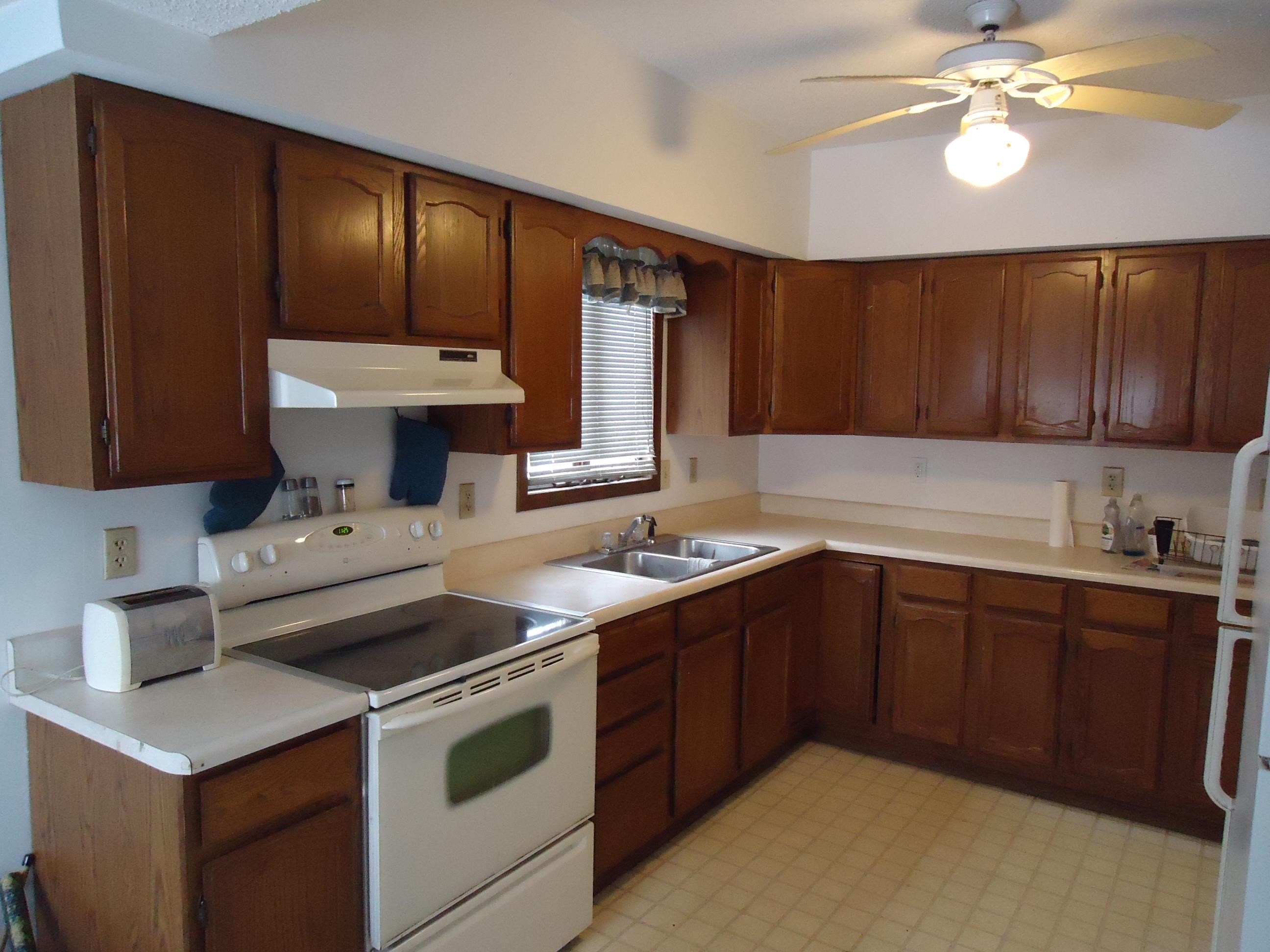 17 3rd Street Southeast Chisholm, MN 55719 - Photo 11 of 28 Kitchen featuring white appliances, light countertops, brown cabinets, under cabinet range hood, and ceiling fan