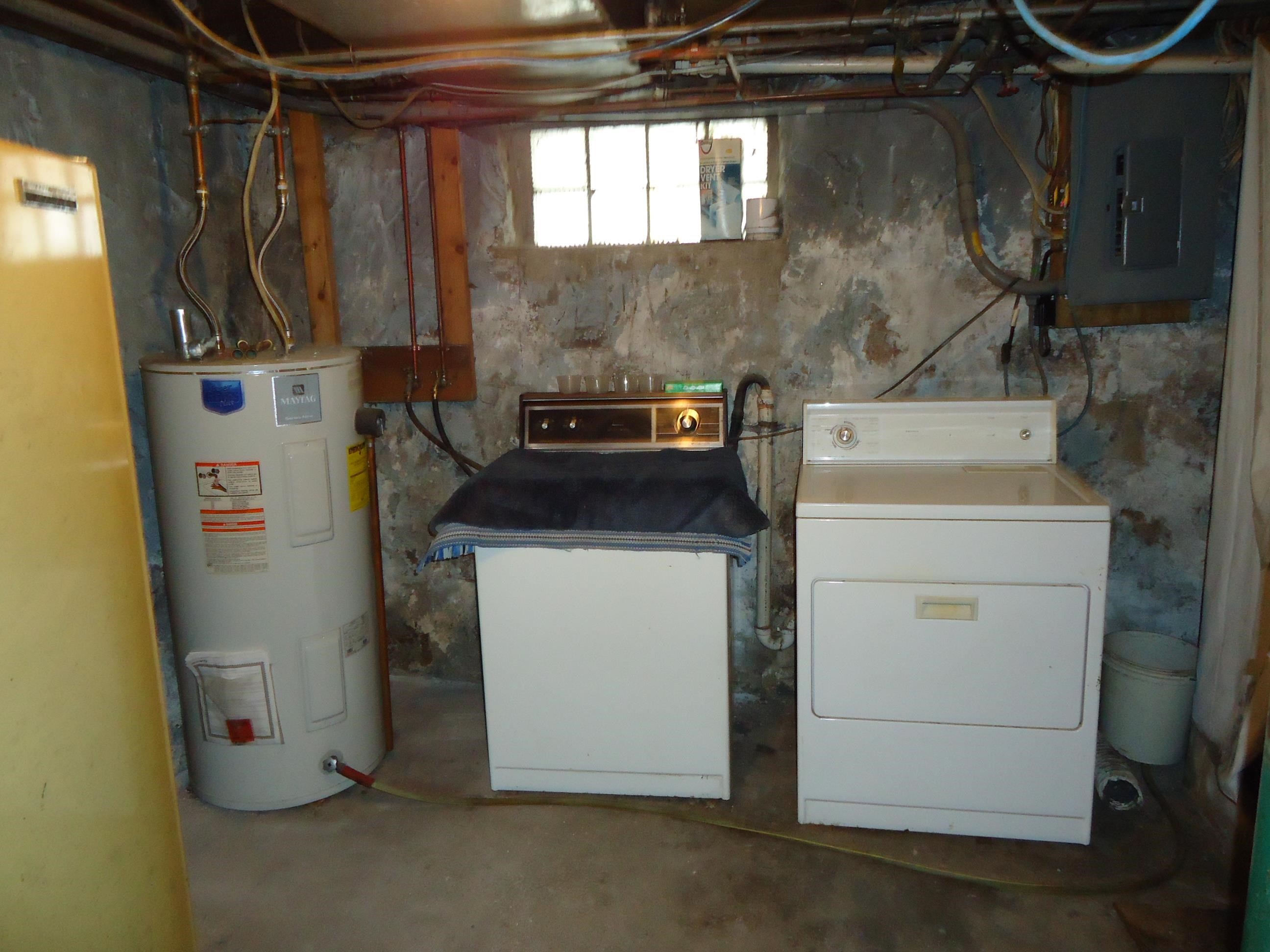 17 3rd Street Southeast Chisholm, MN 55719 - Photo 14 of 28 Laundry room with water heater, electric panel, concrete flooring, and washing machine and dryer