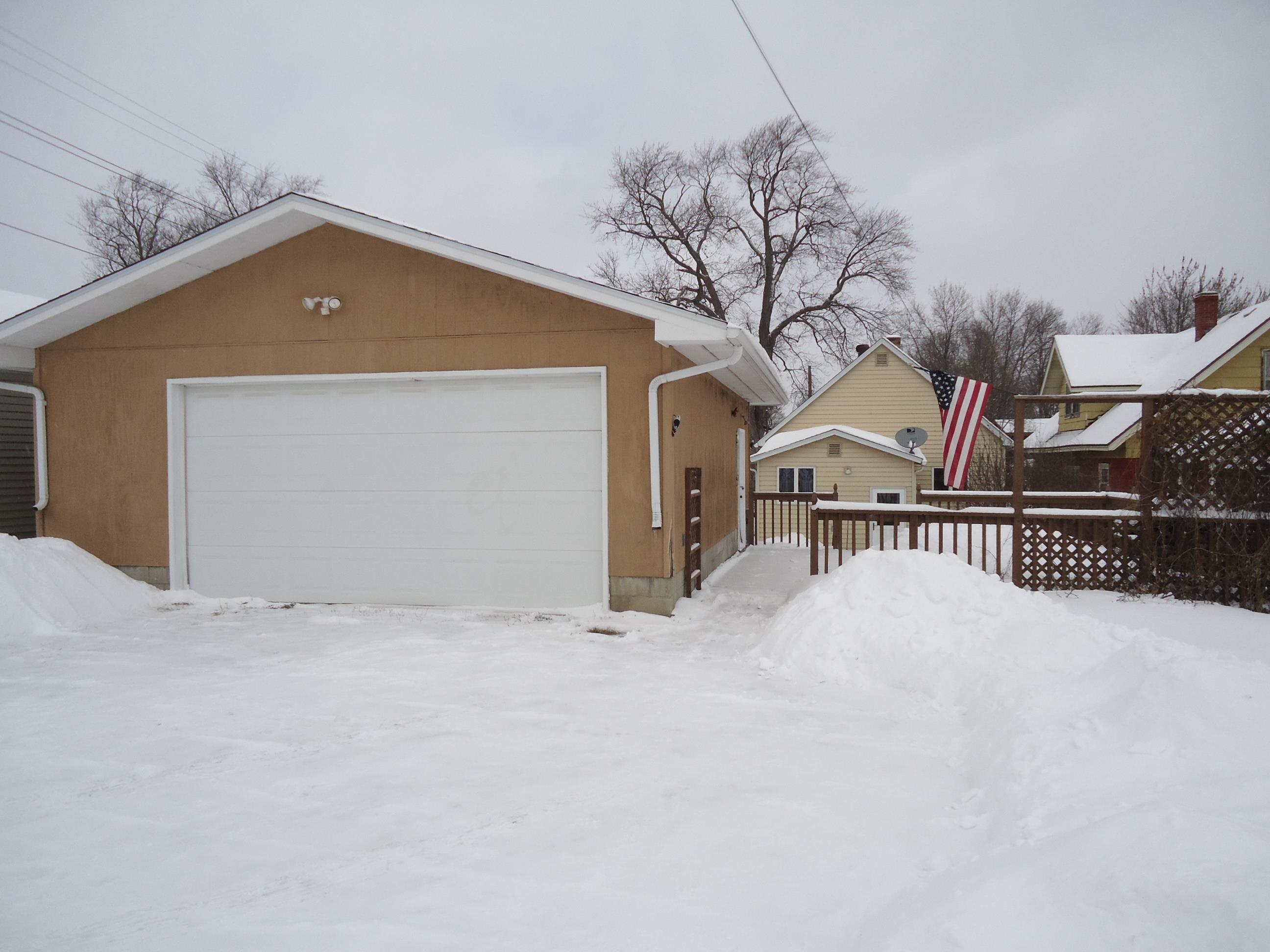 17 3rd Street Southeast Chisholm, MN 55719 - Photo 18 of 28 Snow covered property featuring a garage, a wooden deck, and an outdoor structure
