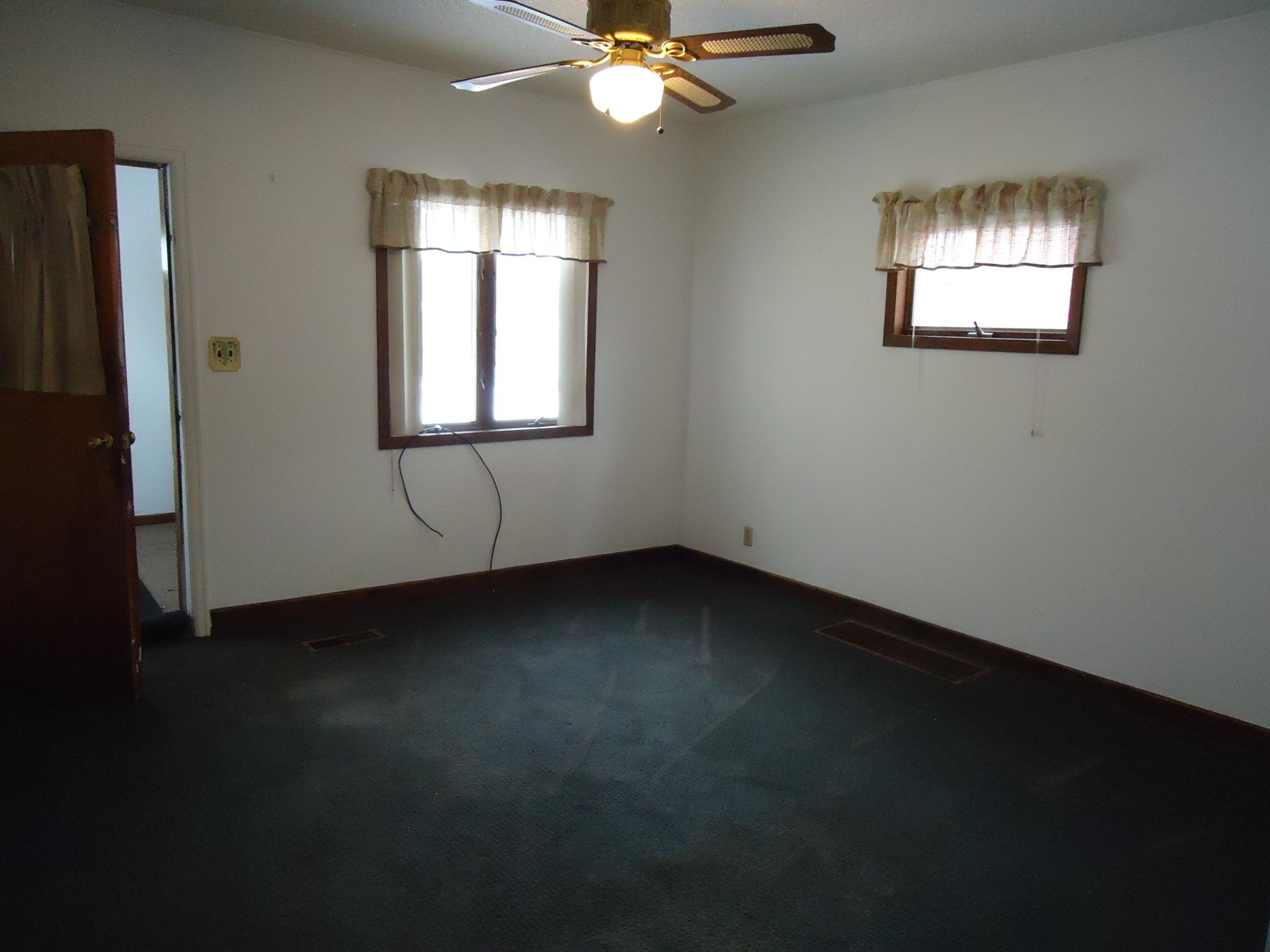 17 3rd Street Southeast Chisholm, MN 55719 - Photo 4 of 28 Unfurnished room featuring dark colored carpet and ceiling fan