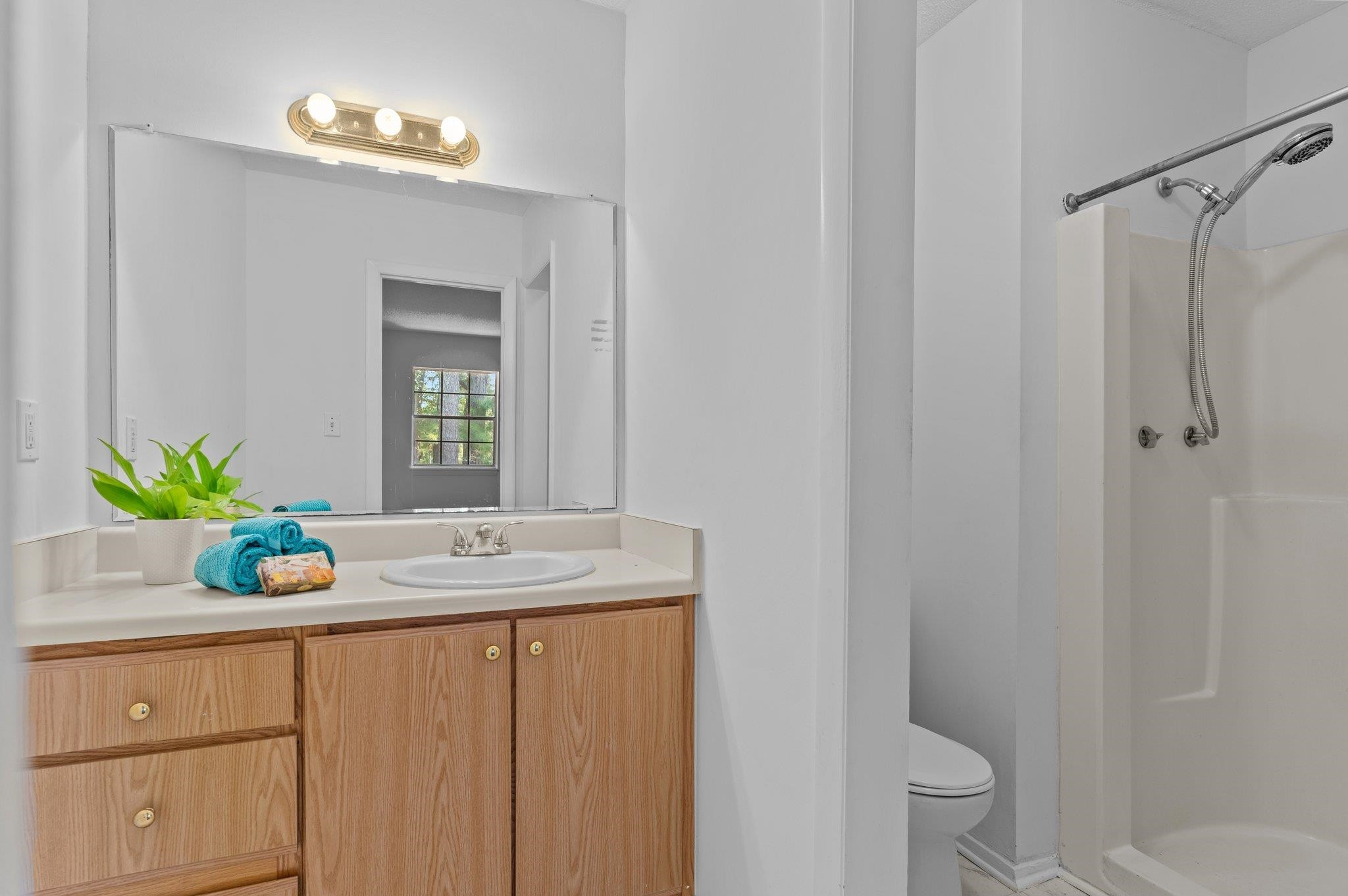 1209 Manassas Court, Unit B Raleigh, NC 27609 - Photo 21 of 34 a bathroom with a granite countertop sink a toilet and a mirror
