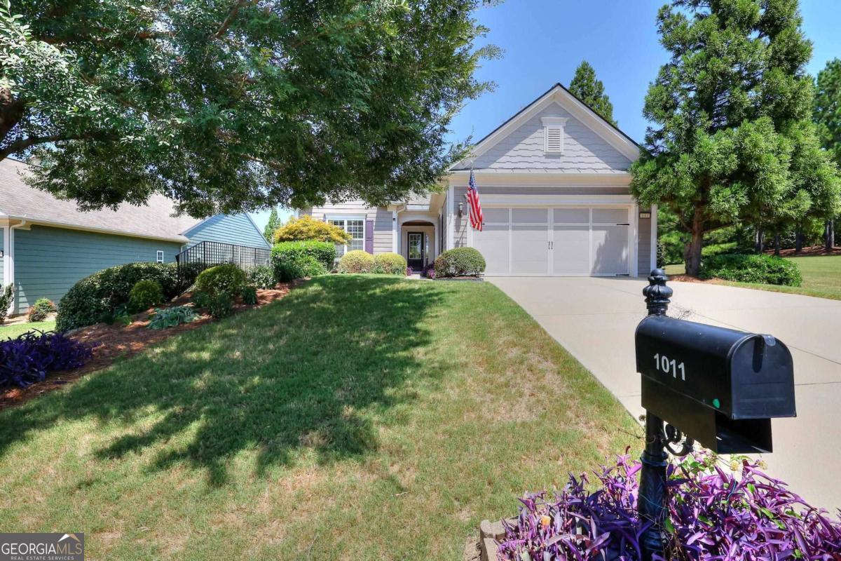 a front view of house with yard and trees in the background
