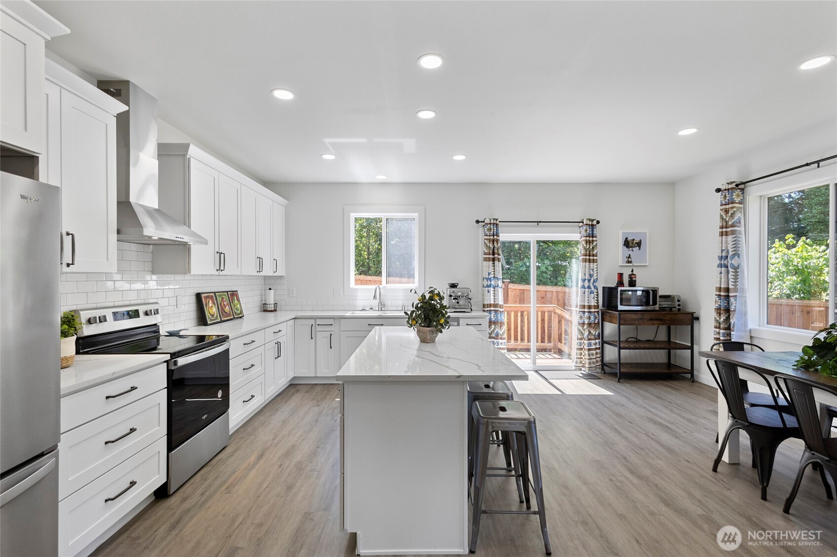 7952 Apache Drive Maple Falls, WA 98266 - Photo 12 of 28 a large kitchen with kitchen island a large island a stove a dining table and chairs
