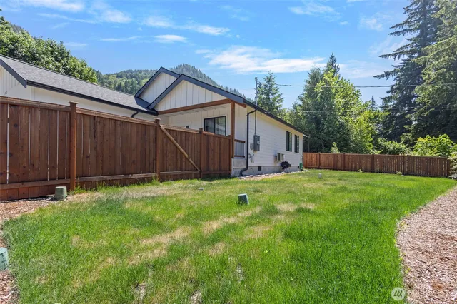 a view of a backyard with wooden fence
