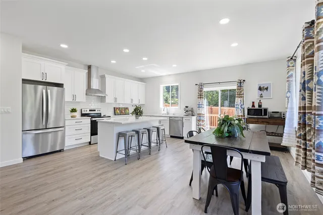 a kitchen with a dining table chairs refrigerator and cabinets