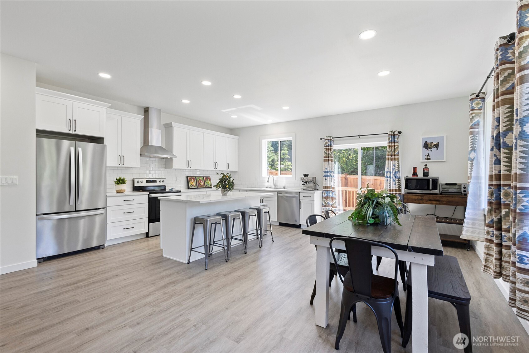7952 Apache Drive Maple Falls, WA 98266 - Photo 5 of 28 a kitchen with a dining table chairs refrigerator and cabinets