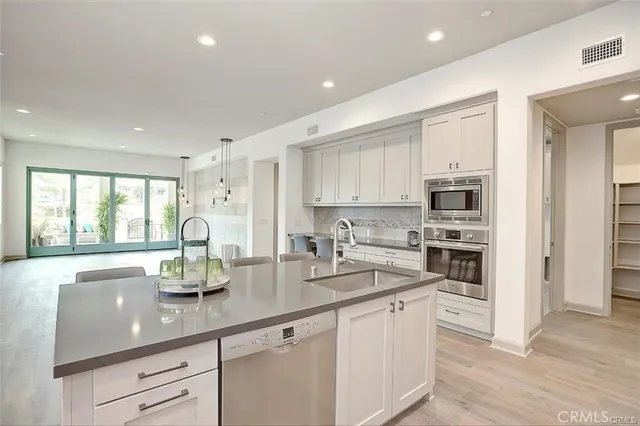 a kitchen with stainless steel appliances granite countertop a stove refrigerator sink and cabinets