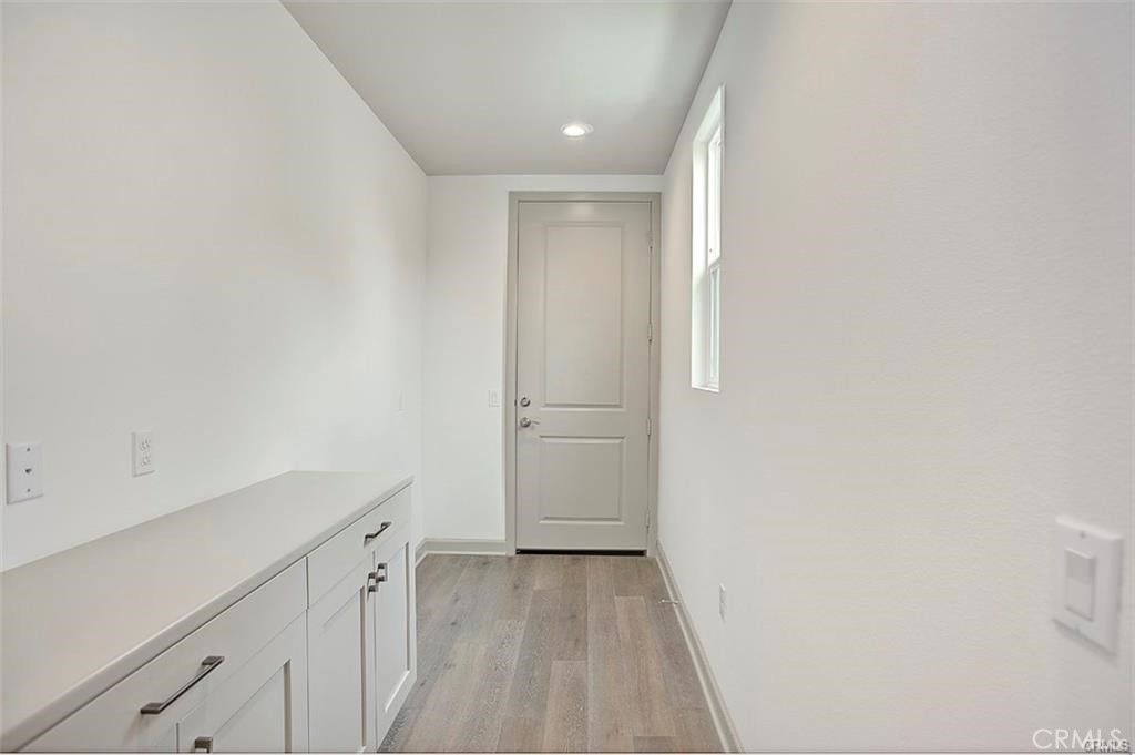 115 Fixie Irvine, CA 92618 - Photo 22 of 29 a view of a kitchen with white cabinets and wooden floor